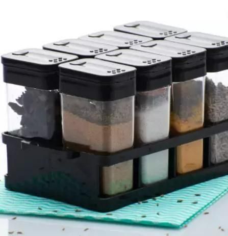 Set of airtight spice jar set with black lids and clear containers organized on a black rack