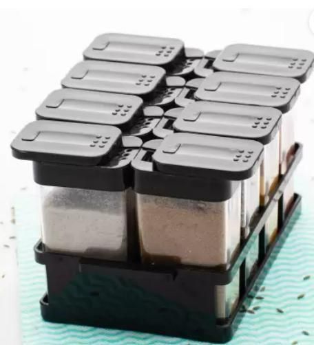 Set of eight airtight spice jar set with black lids and clear containers in a black tray organizer