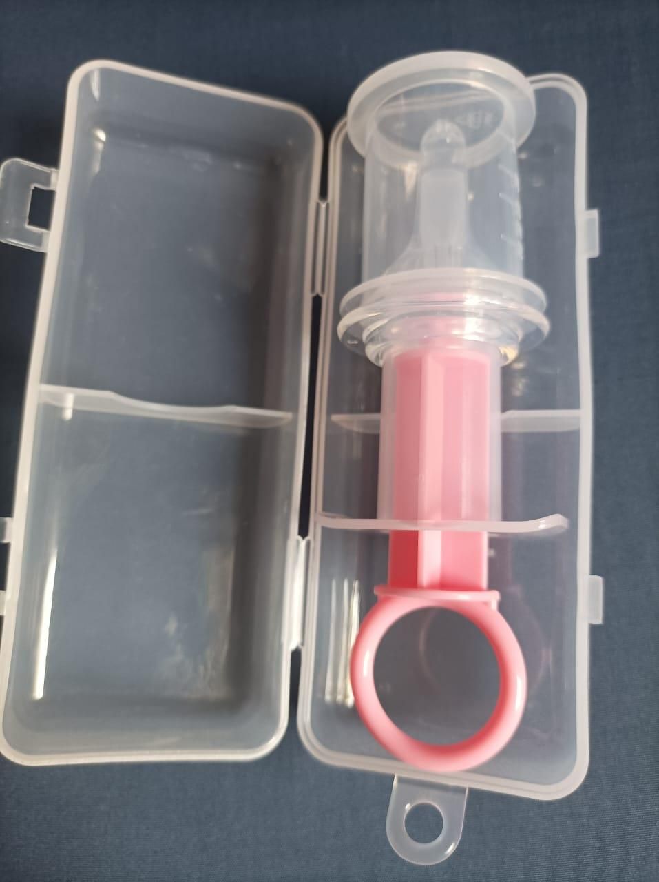 Pink needle feeder for infants in protective case for safe food feeding
