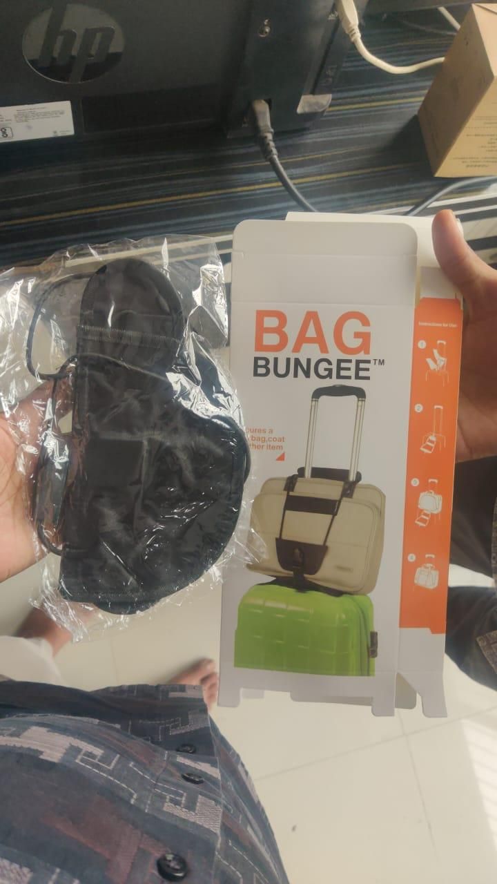 Bag Bungee adjustable luggage strap packaging and black bungee strap in plastic showing strap securing bag to suitcase