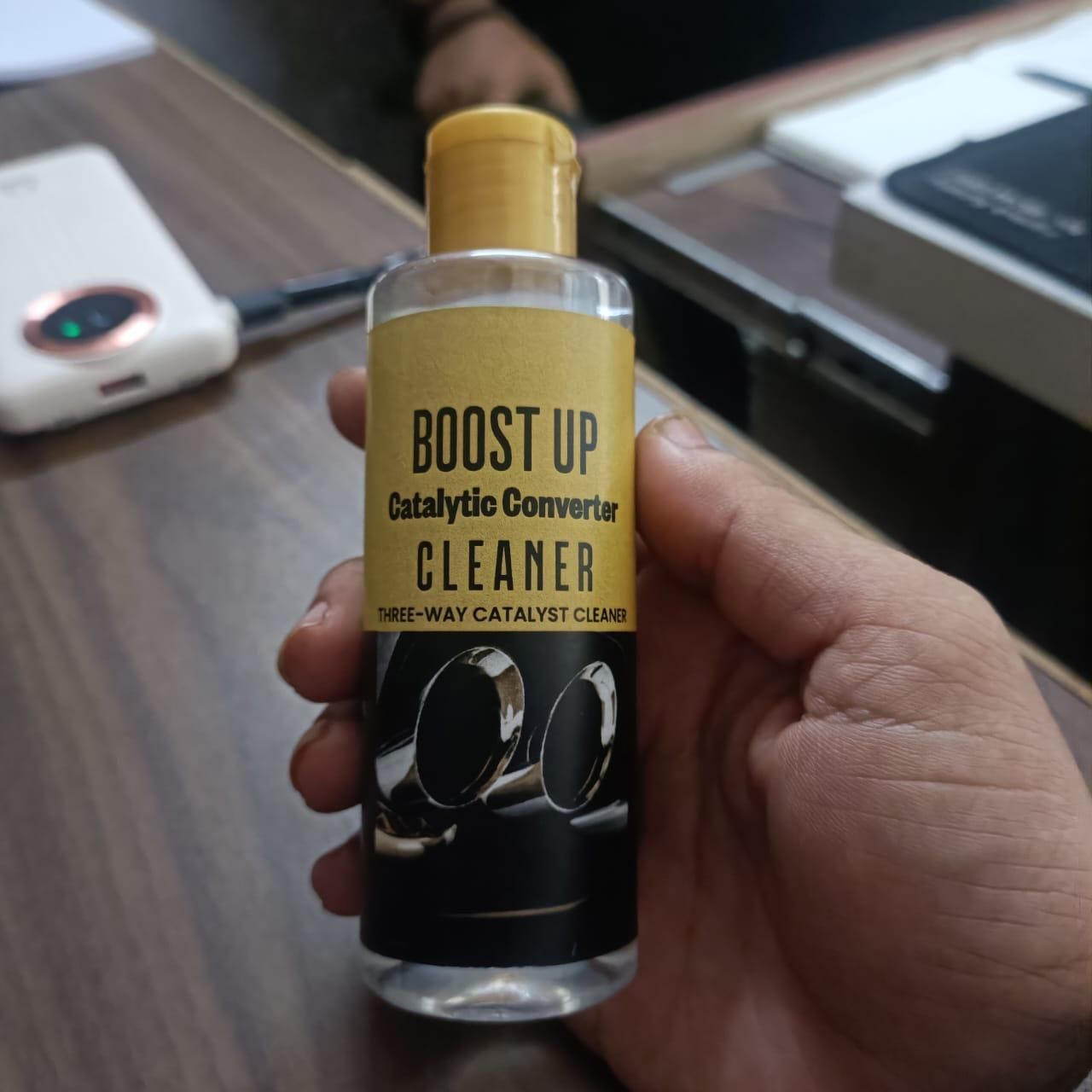 Boost Up catalytic converter cleaner bottle held in hand for fuel injector cleaner for cars