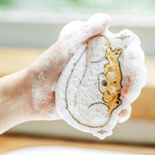 Hand holding a cartoon wood pulp dish sponge covered in soap suds for efficient cleaning