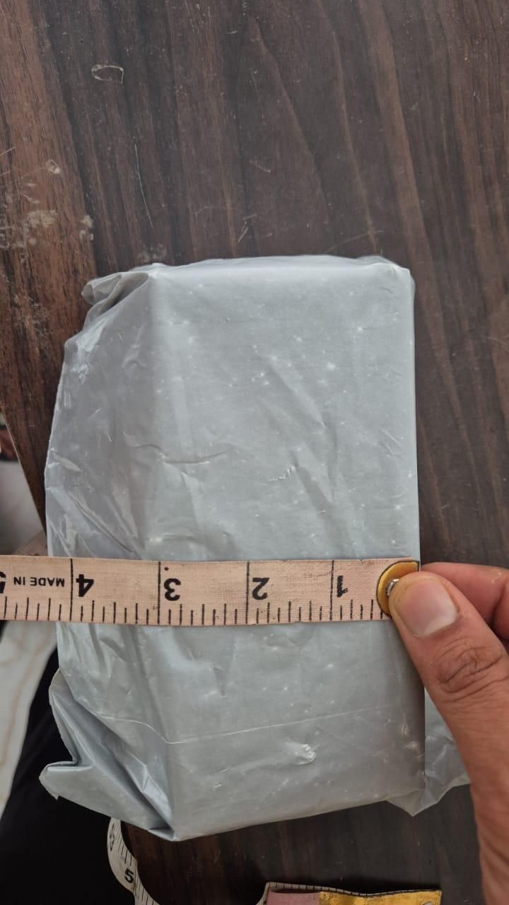 Aquarium water cleaner for freshwater and saltwater packaged in a sealed white plastic bag measured with a ruler