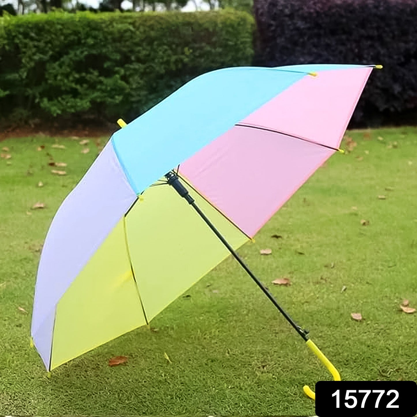 colorful rainbow umbrella with pastel blue pink yellow and purple panels on grass