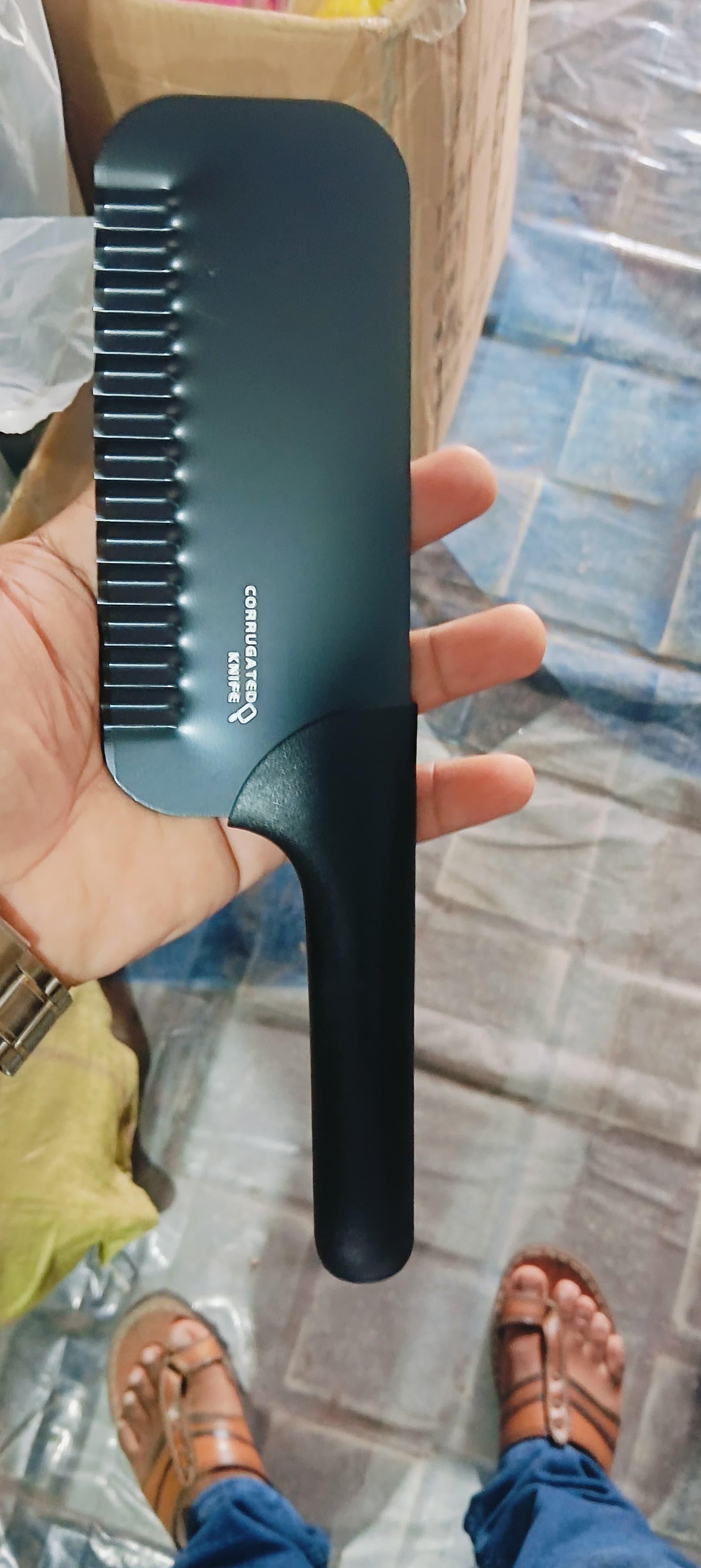 THE GIR FARMER black crinkled chopper kitchen tool held in hand for chopping vegetables