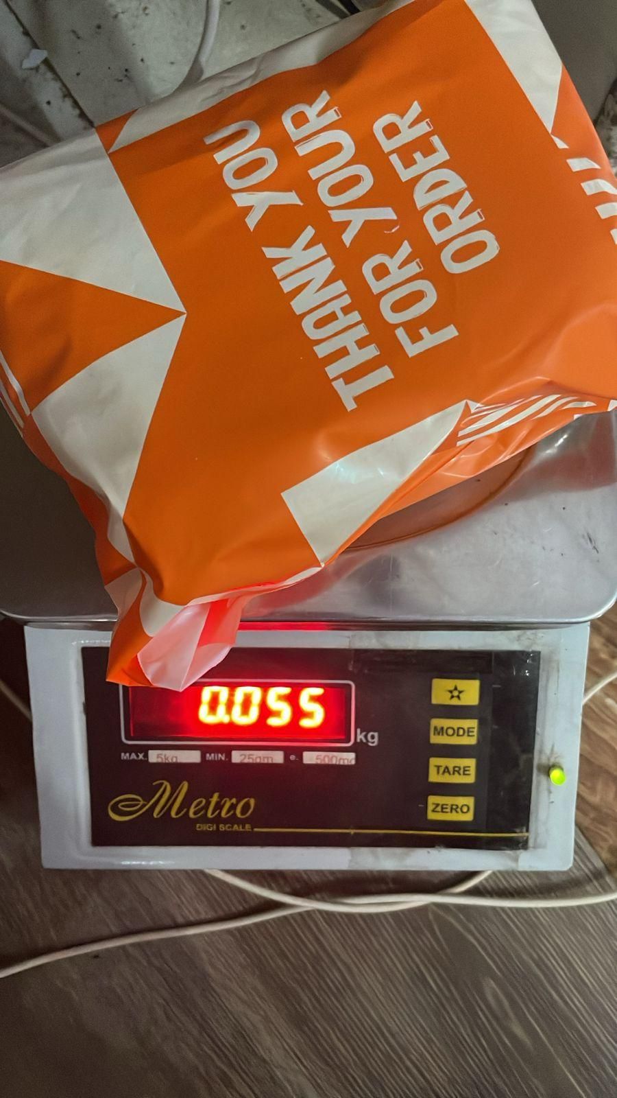 THE GIR FARMER package on a digital scale weighing 0.055 kilograms showing decorative light switch stickers order