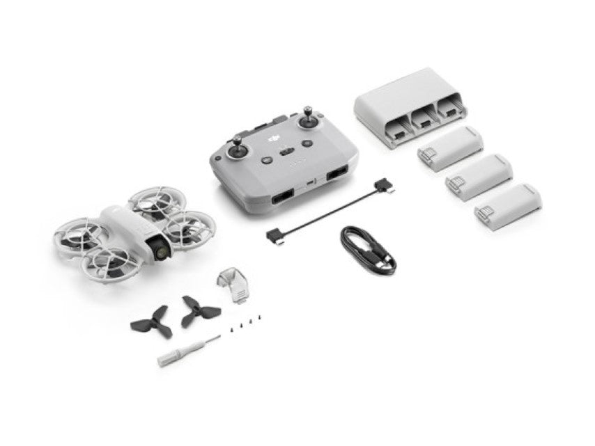 DJI Neo Fly More Combo drone with remote, batteries, propellers, and charging accessories neatly arranged