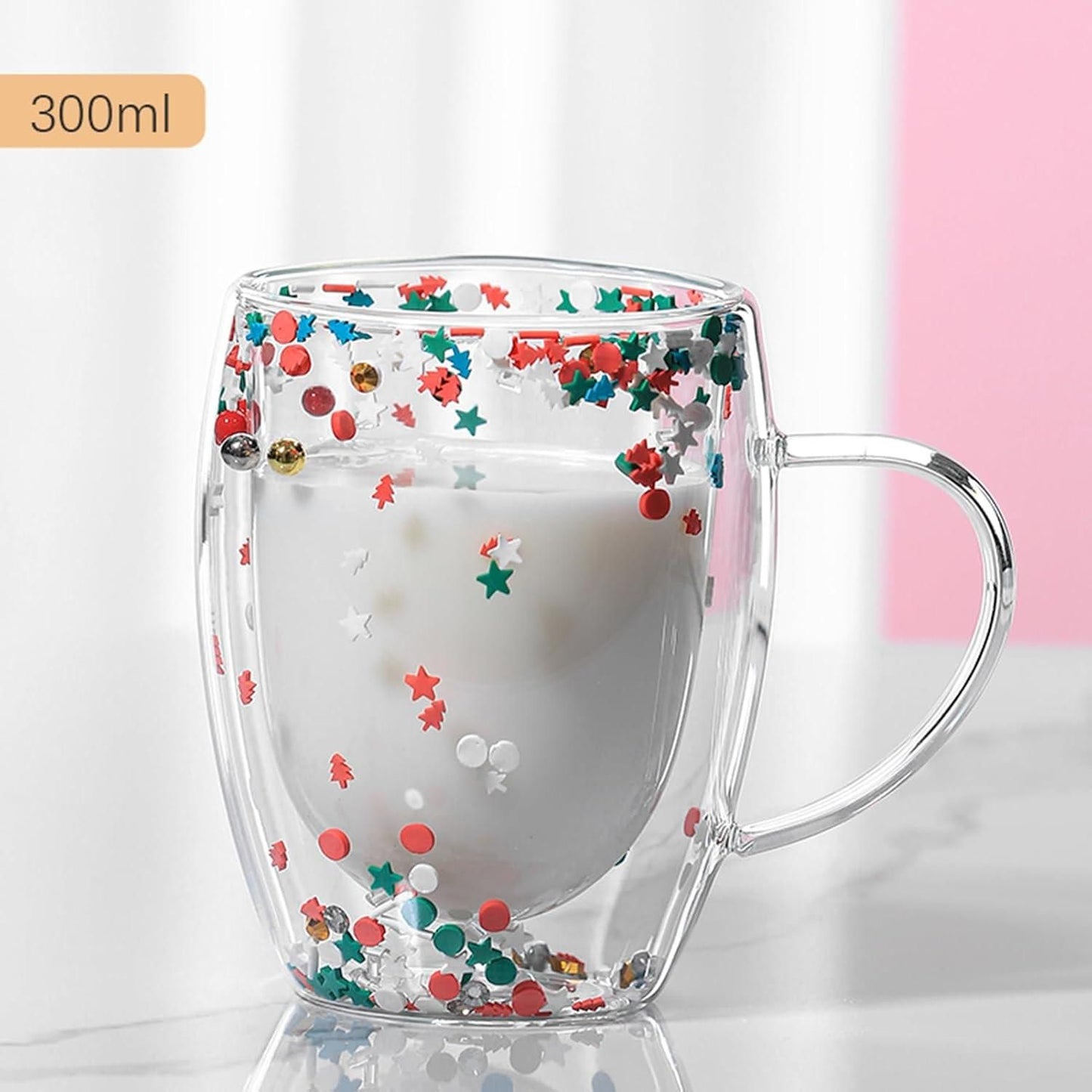 THE GIR FARMER double walled glass coffee mug with festive confetti design holding milk