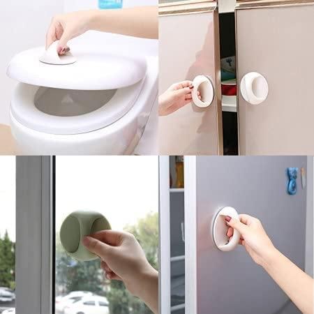 Round white and green suction style adhesive handles for cabinets used on toilet lids windows and doors