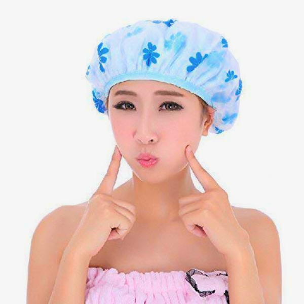 Woman wearing a blue floral elastic band shower cap for long hair protecting hair during shower