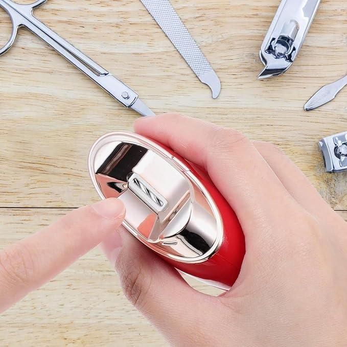 Person using an electric nail clipper surrounded by grooming tools on a wooden surface