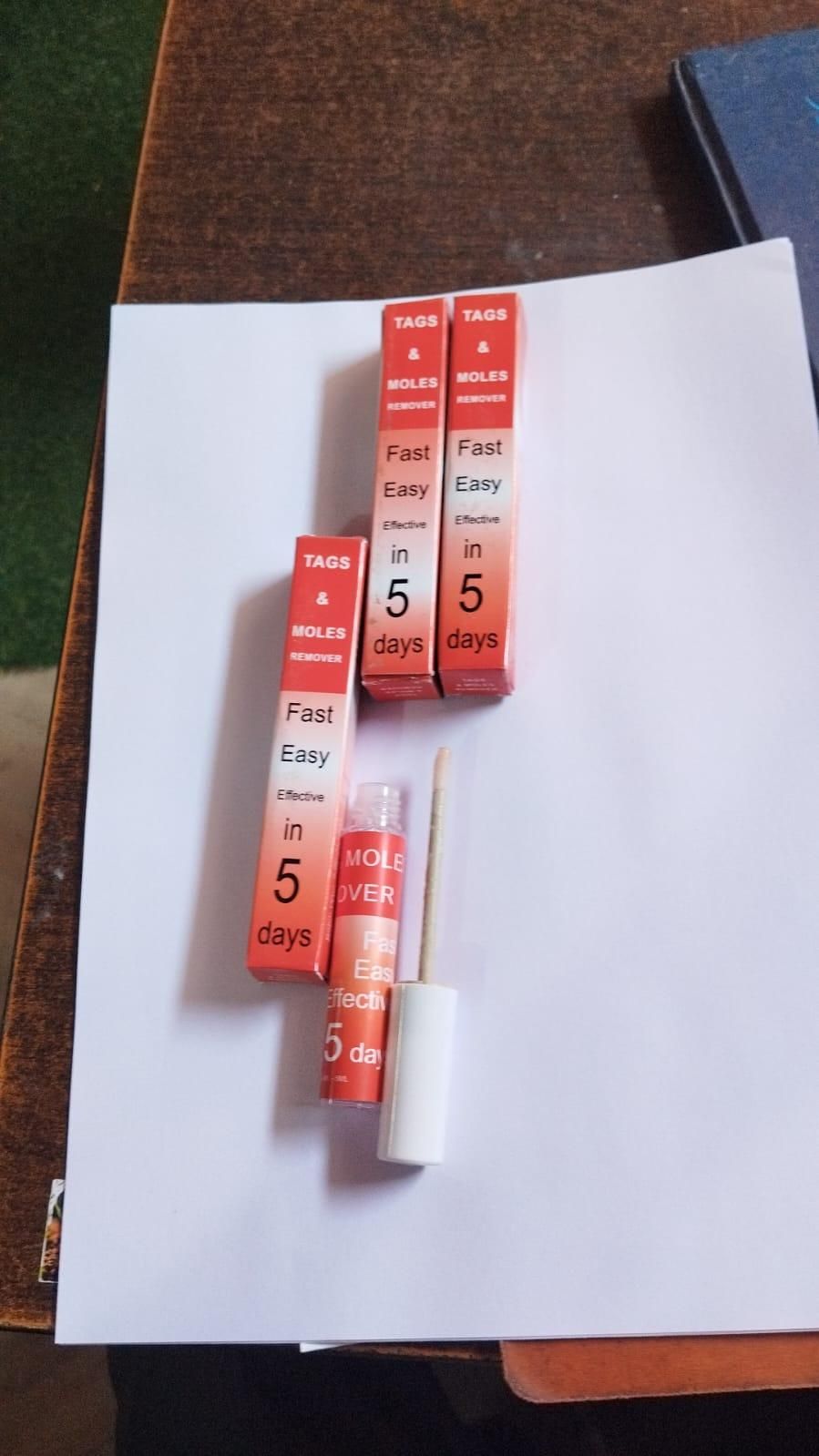 Fast acting tag and mole remover with applicator brush and packaging showing treatment in 5 days