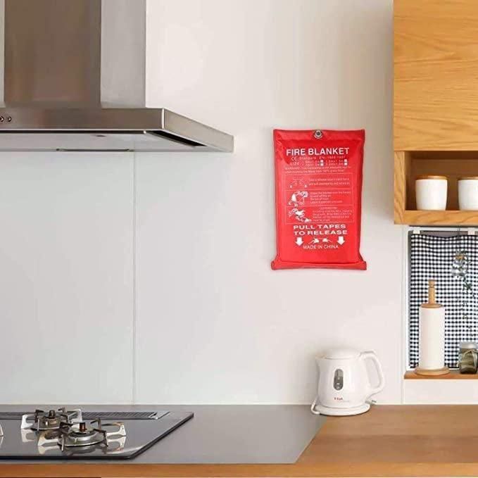 Fire safety blanket for home in red pouch hanging on kitchen wall near stove and kettle