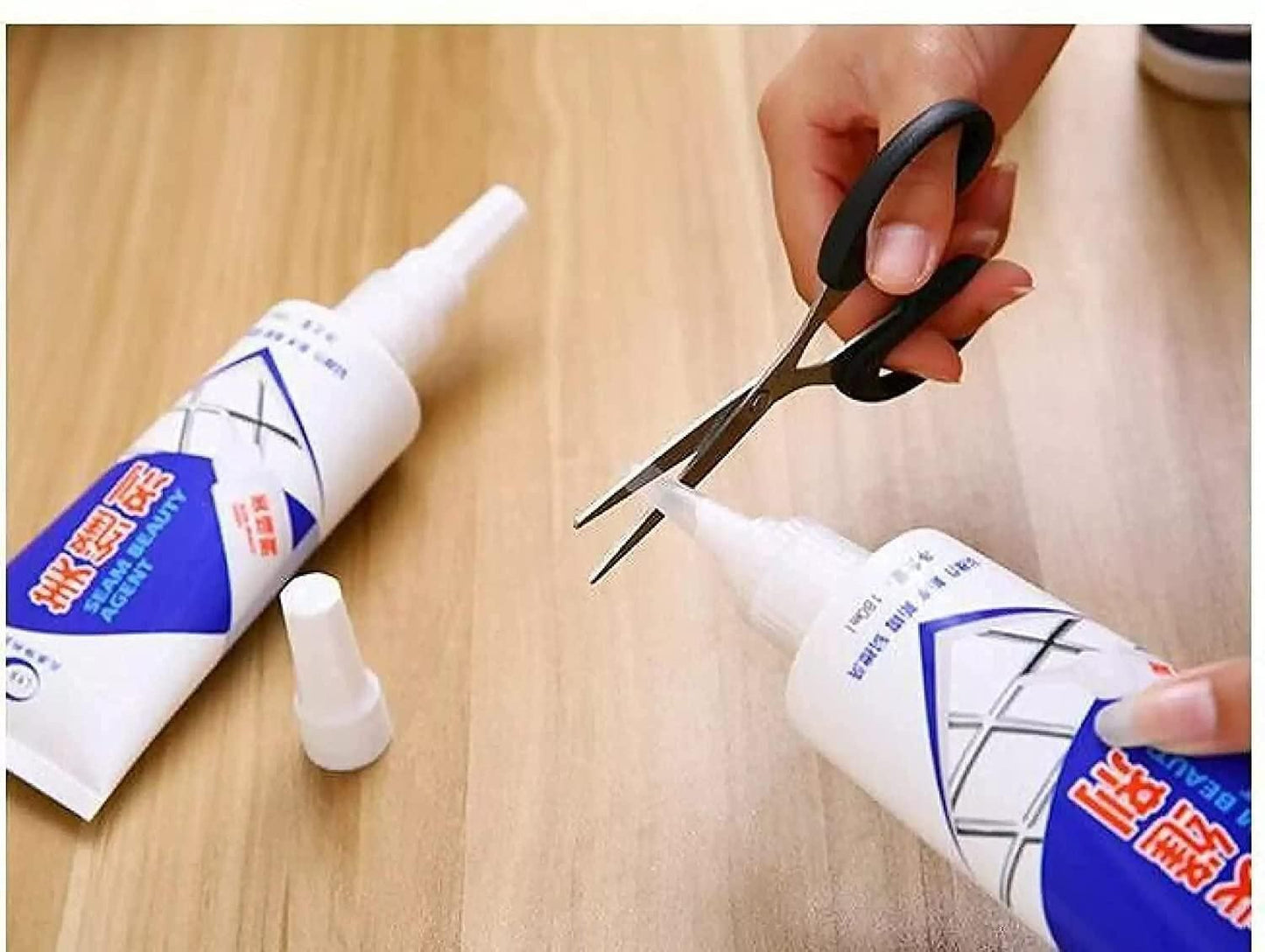 Person cutting the tip of a gap filler tube for home repair on a wooden surface