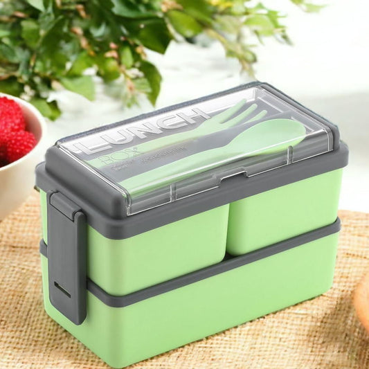Green bento compartment lunch box with secure gray clasps and transparent lid with utensils