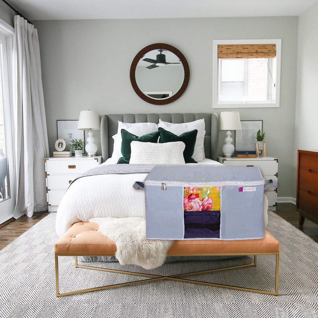 Large capacity storage bags for bedding in gray fabric placed on bedroom bench with floral bedding inside