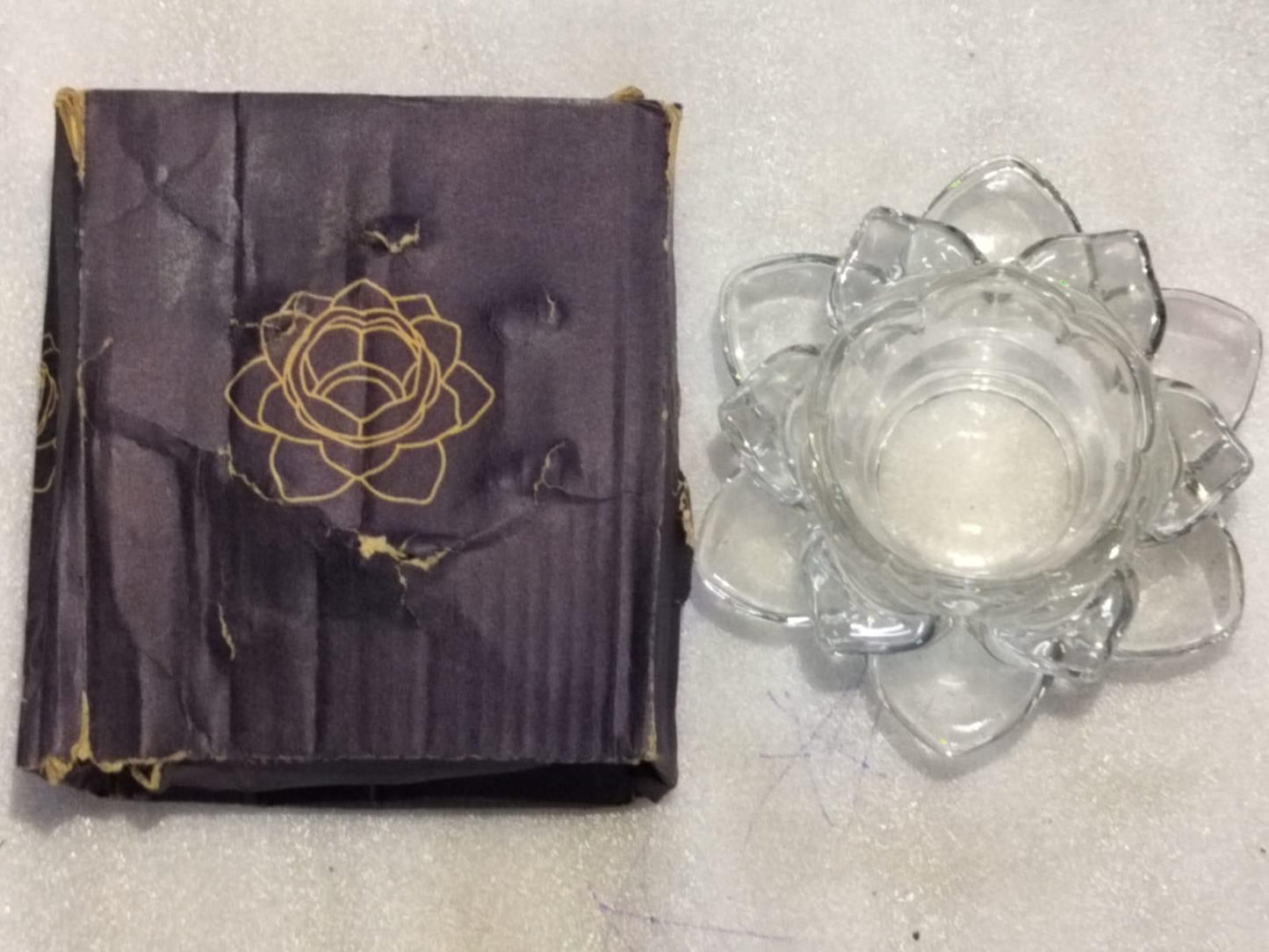 THE GIR FARMER glass lotus tea light holder made of clear glass with lotus petal design next to its decorative box