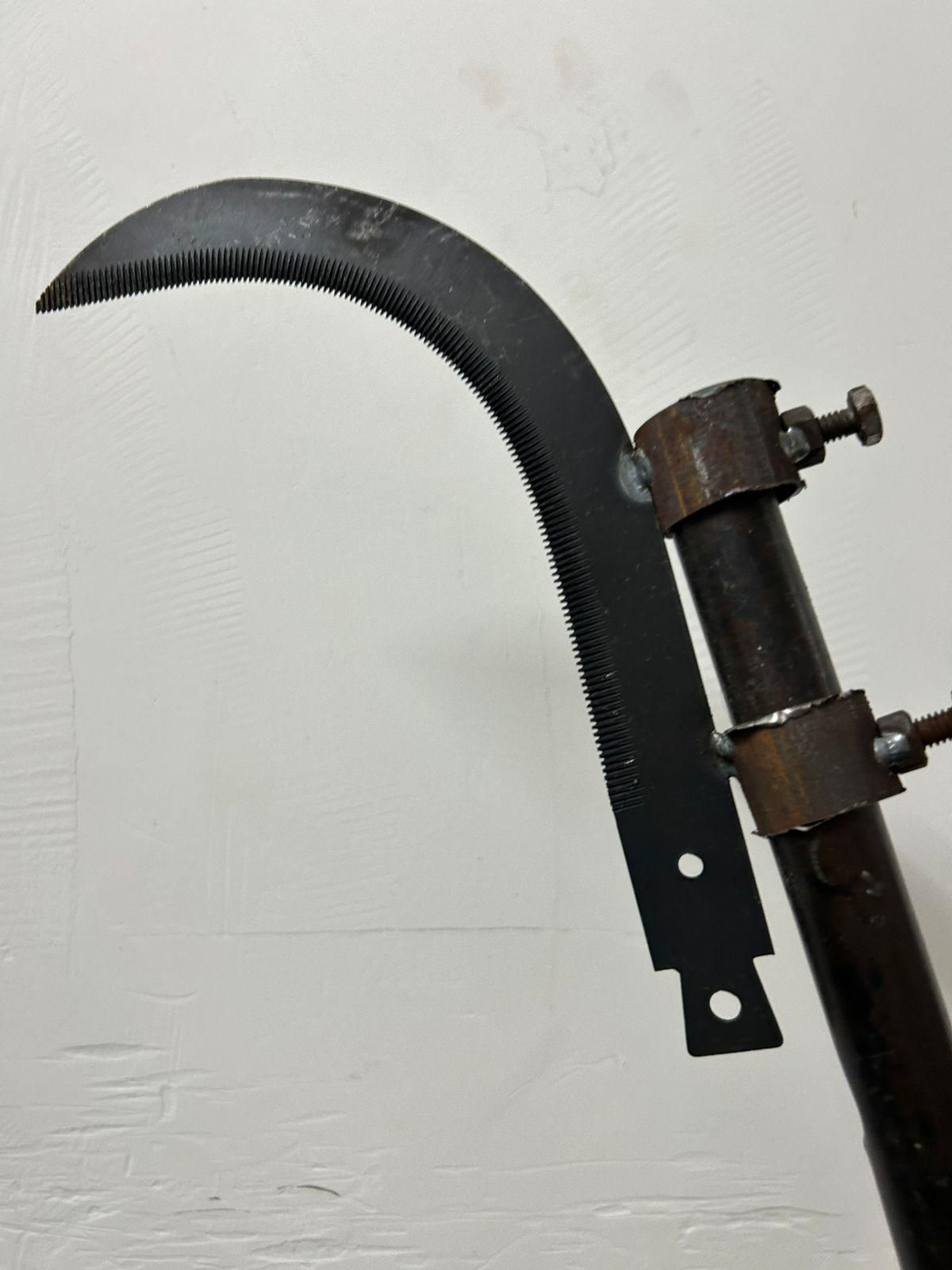 Close-up of a grass sickle cutter head with a sharp curved blade for efficient grass cutting