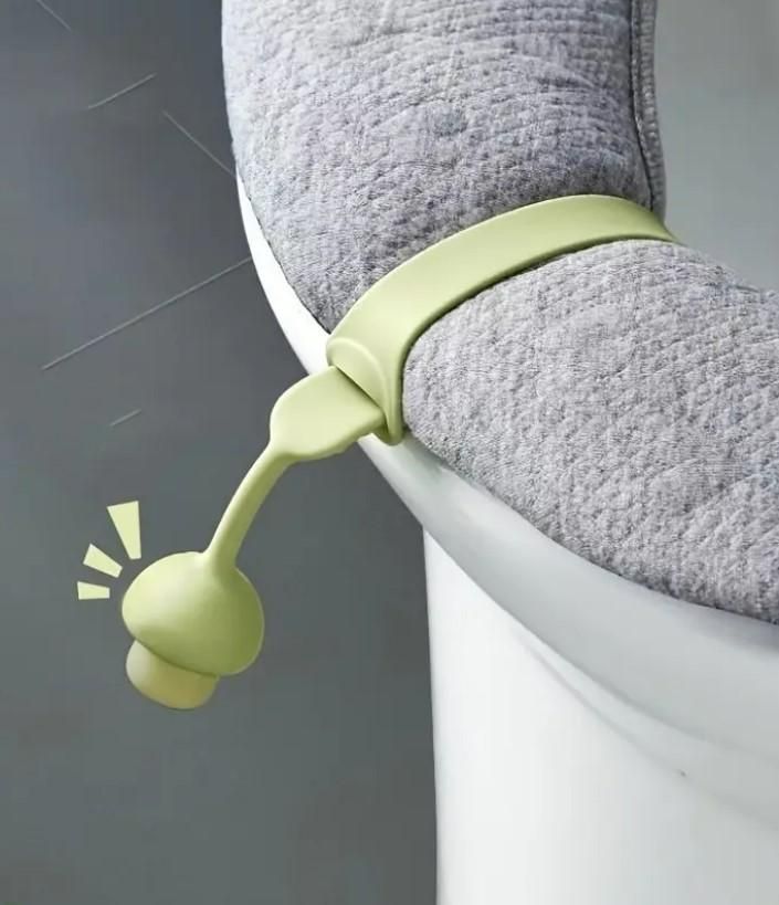 Green hygienic toilet lid lifter attached to gray toilet seat cover for hands-free use
