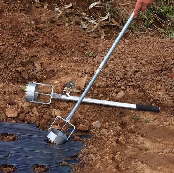 The Gir Farmer greenhouse film punch tool with long handles creating circular holes in black plastic mulch