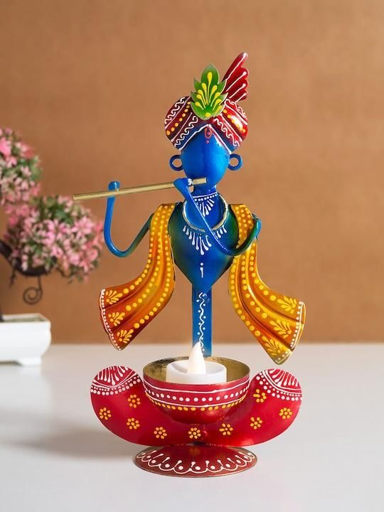 Handcrafted Krishna statue for home in vibrant colors holding a flute with decorative base and candle holder