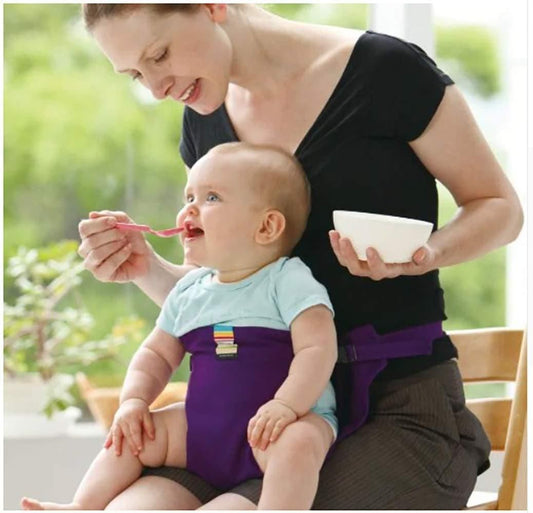 Mom feeding baby using a high chair safety seat for babies attached to her lap