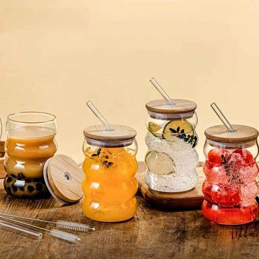 Set of four wave shape glass with wood cap jars with glass straws filled with boba and colorful drinks