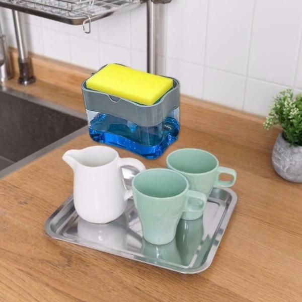 Kitchen dish soap dispenser with blue container and yellow sponge on wooden countertop near sink