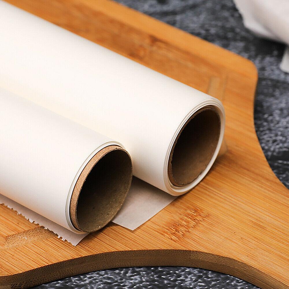 Two white rolls of microwave oven safe baking paper on wooden cutting board for baking and food prep