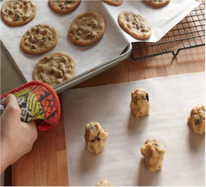 Your Brand microwave oven safe baking paper on baking sheet with baked chocolate chip cookies and cookie dough
