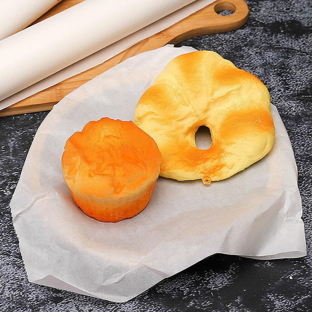 Two baked goods on microwave oven safe baking paper with parchment roll and wooden cutting board
