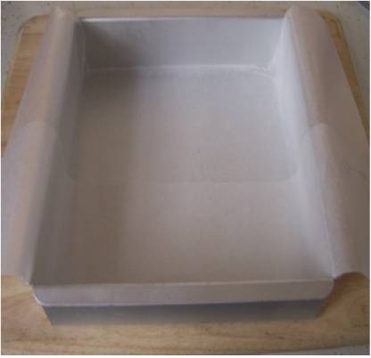 Your Brand square baking pan lined with microwave oven safe baking paper folded over edges for easy release and cleanup