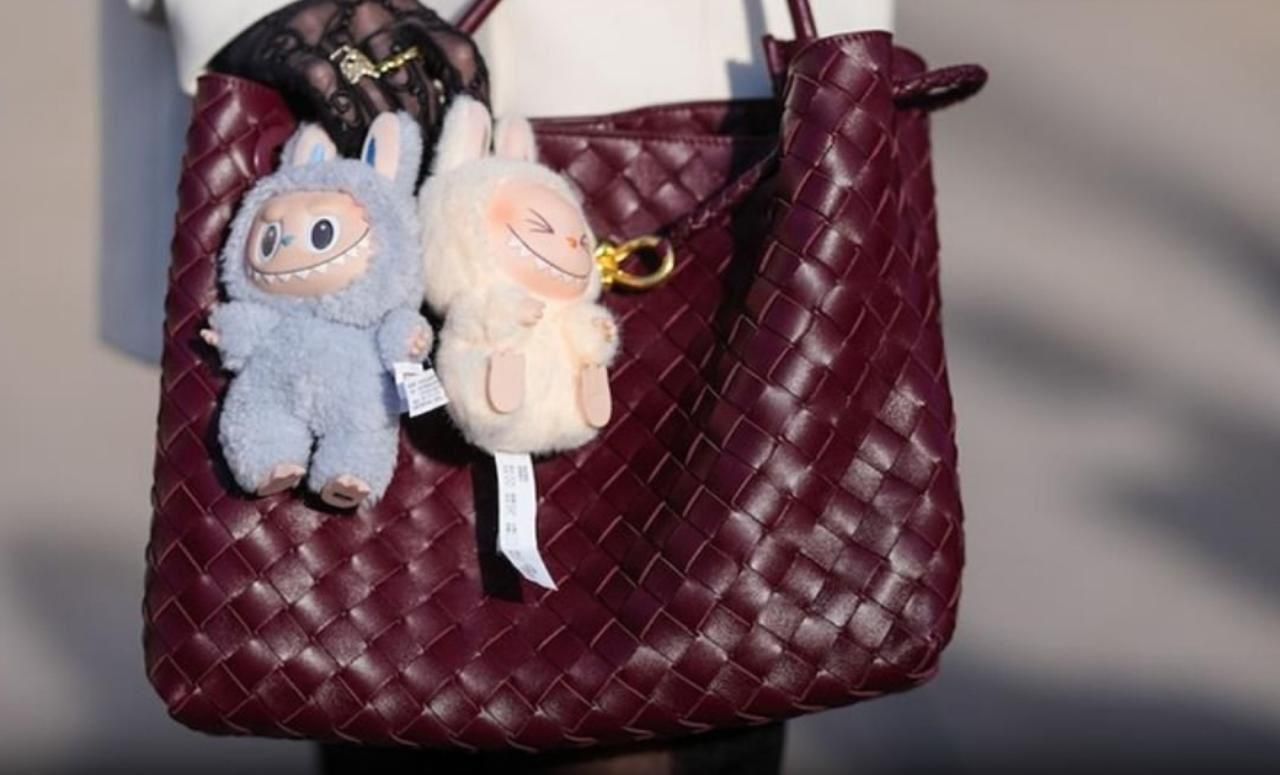 Labubu plush doll keychains attached to a woven burgundy leather handbag by THE GIR FARMER
