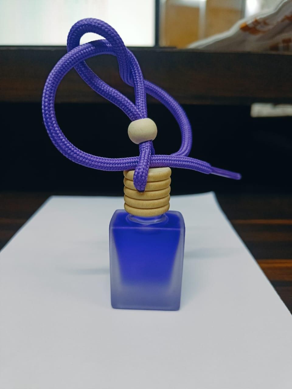 Lavender car air freshener in a blue glass bottle with a purple rope for a refreshing scent