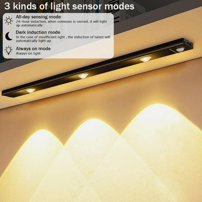 Black LED motion sensor cabinet light with three sensor modes illuminating a wall with warm light