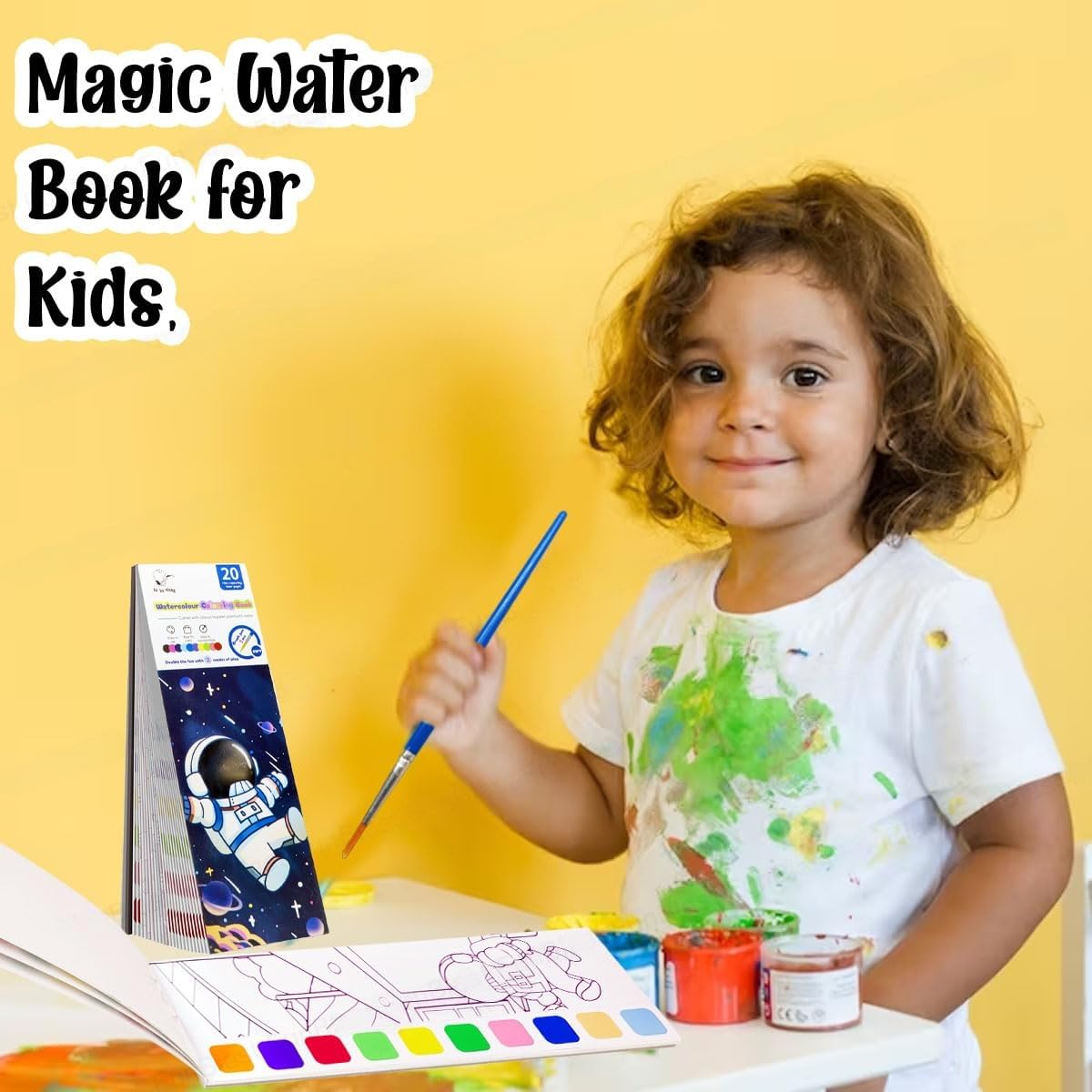 Child using magic water coloring book for kids with paintbrush and colorful paint pots on table