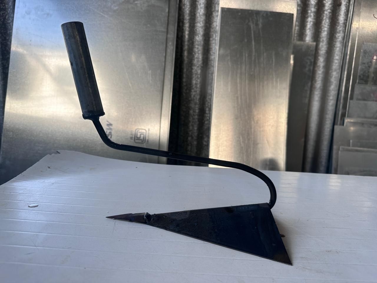 Manual soil cultivator tool with a black metal blade and ergonomic handle for gardening