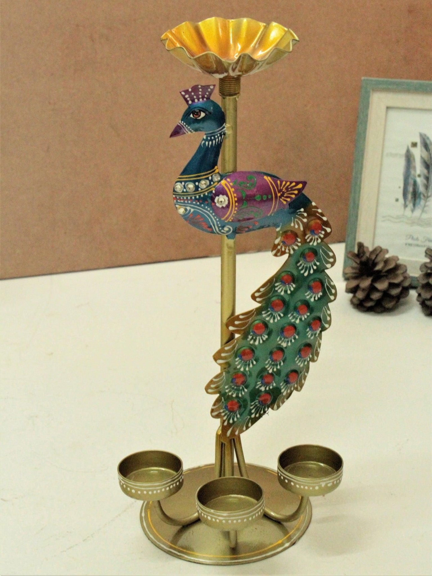 Colorful metal peacock tea light stand with three holders and decorative tail feathers
