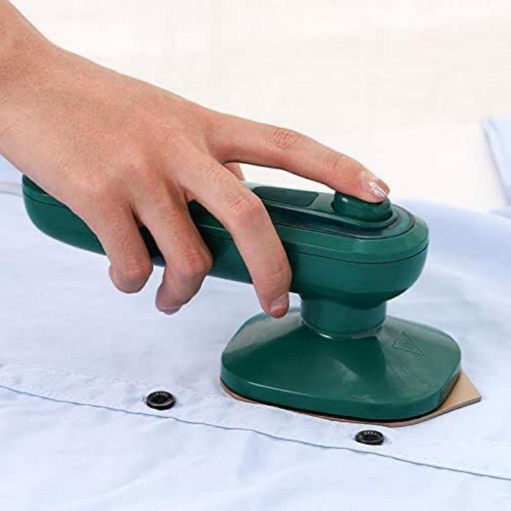 THE GIR FARMER mini garment steamer for home and travel in green held over light blue shirt