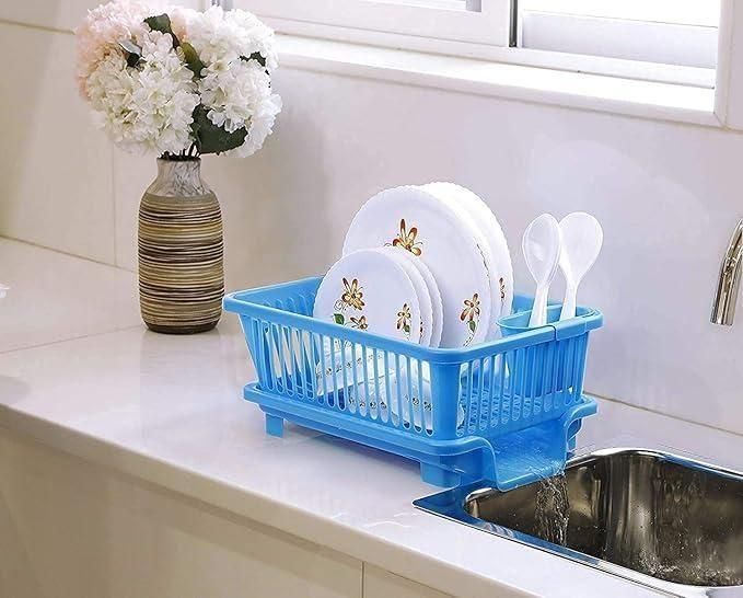 Blue multi-functional dish drying rack with plates and spoons placed next to kitchen sink