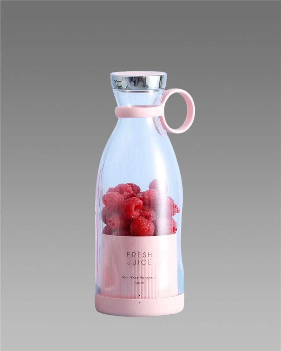 Pink compact blender for travel with fresh raspberries inside and silver lid