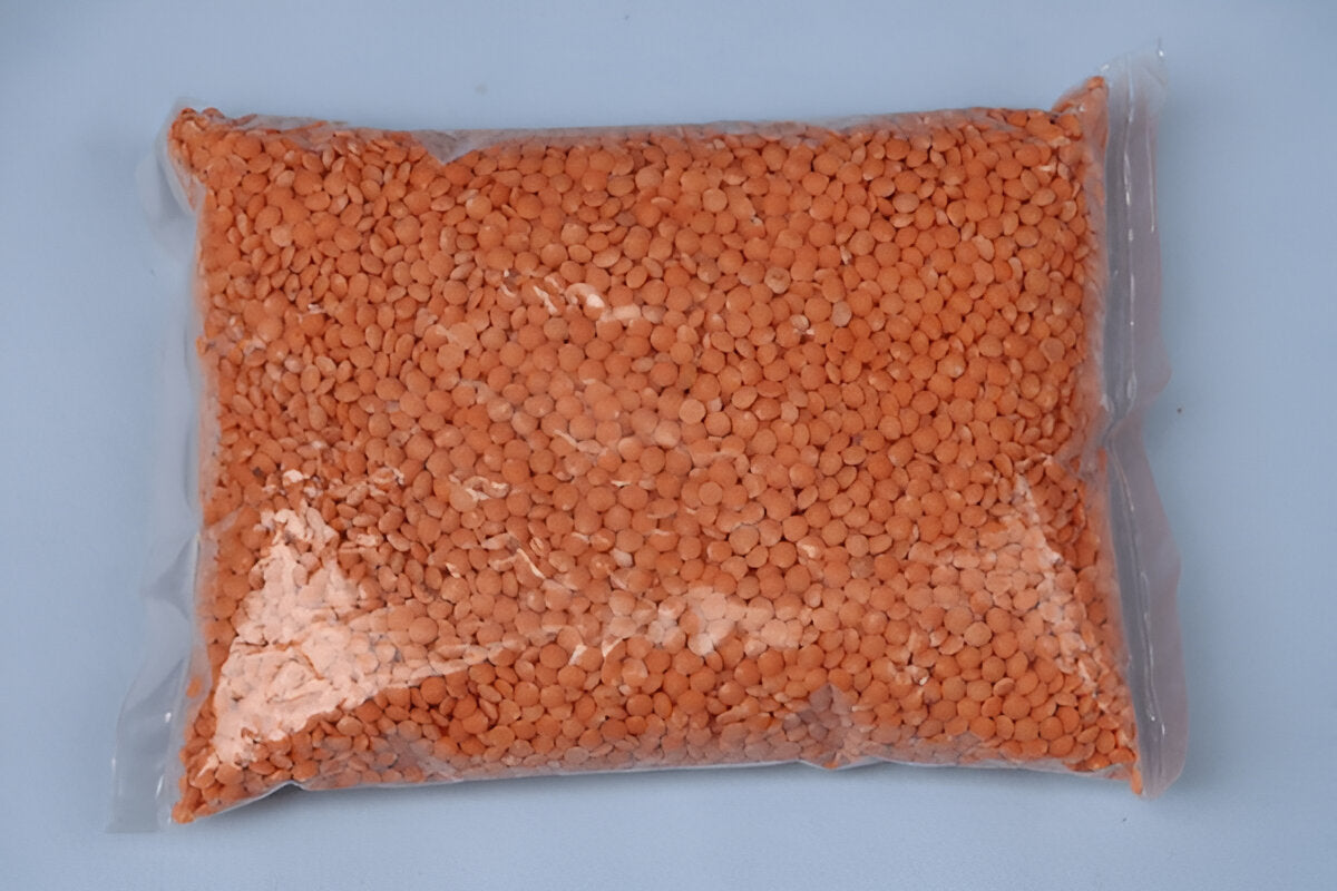 THE GIR FARMER organic masoor dal packed in a transparent plastic bag on a light blue background