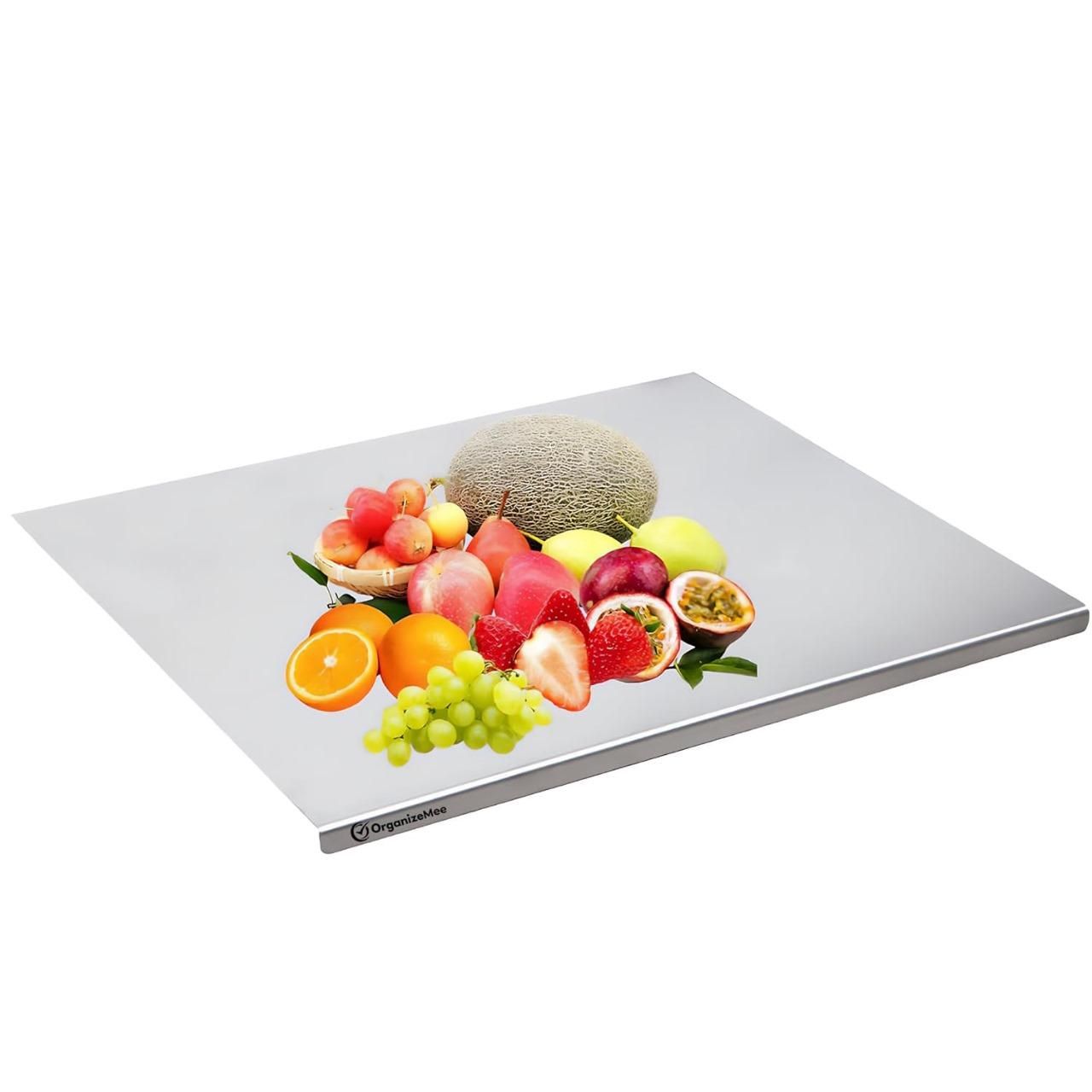 Stainless steel chopping board with assorted fresh fruits including strawberries, grapes, oranges, and melon