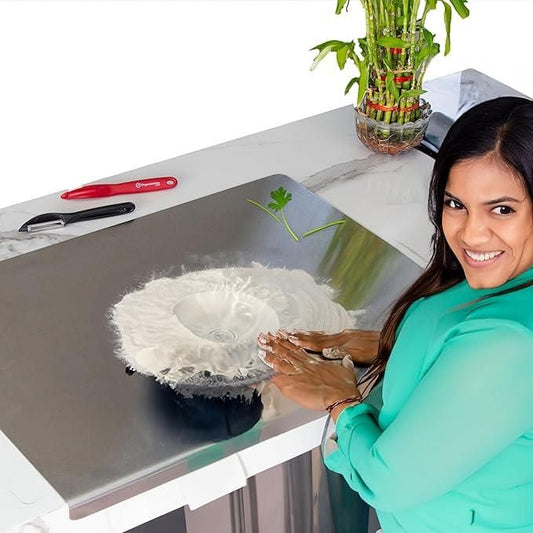 Woman using a stainless steel chopping board with flour on a kitchen counter and kitchen tools nearby