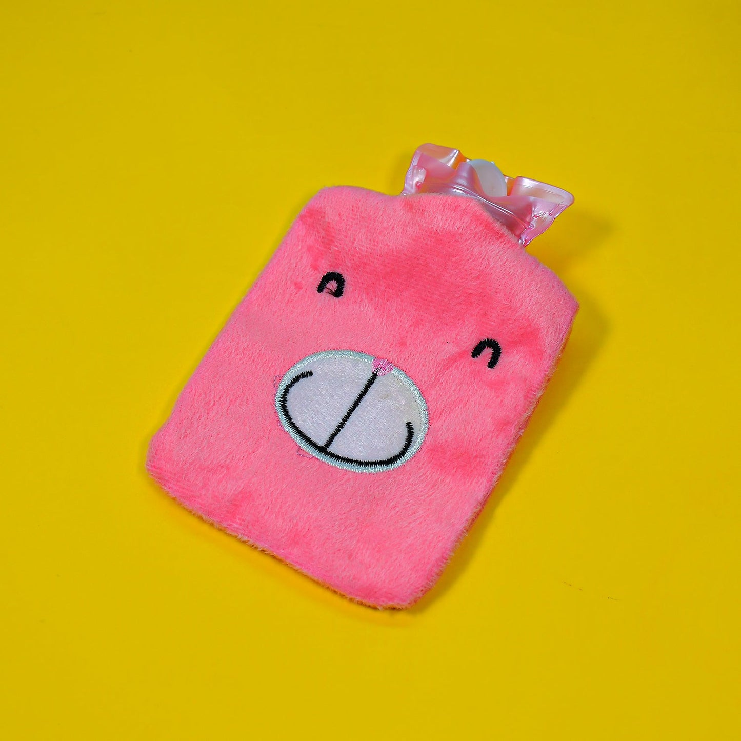 Cute pink hot water bag for cramps with a bear face design, perfect for soothing comfort