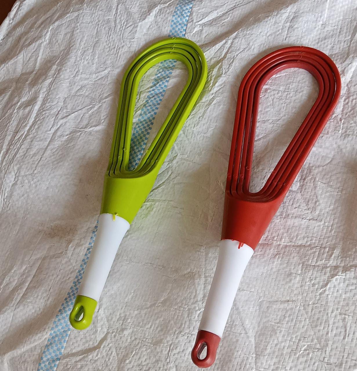 Set of two plastic balloon whisk mixers in green and red for easy food blending