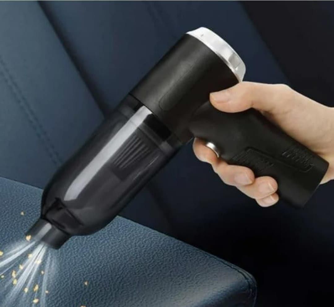 Handheld portable vacuum suction cleaner in black removing crumbs from blue leather couch