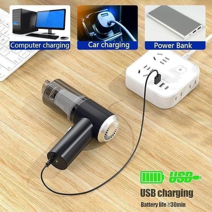 Portable vacuum suction cleaner charging via USB from power bank on wooden surface