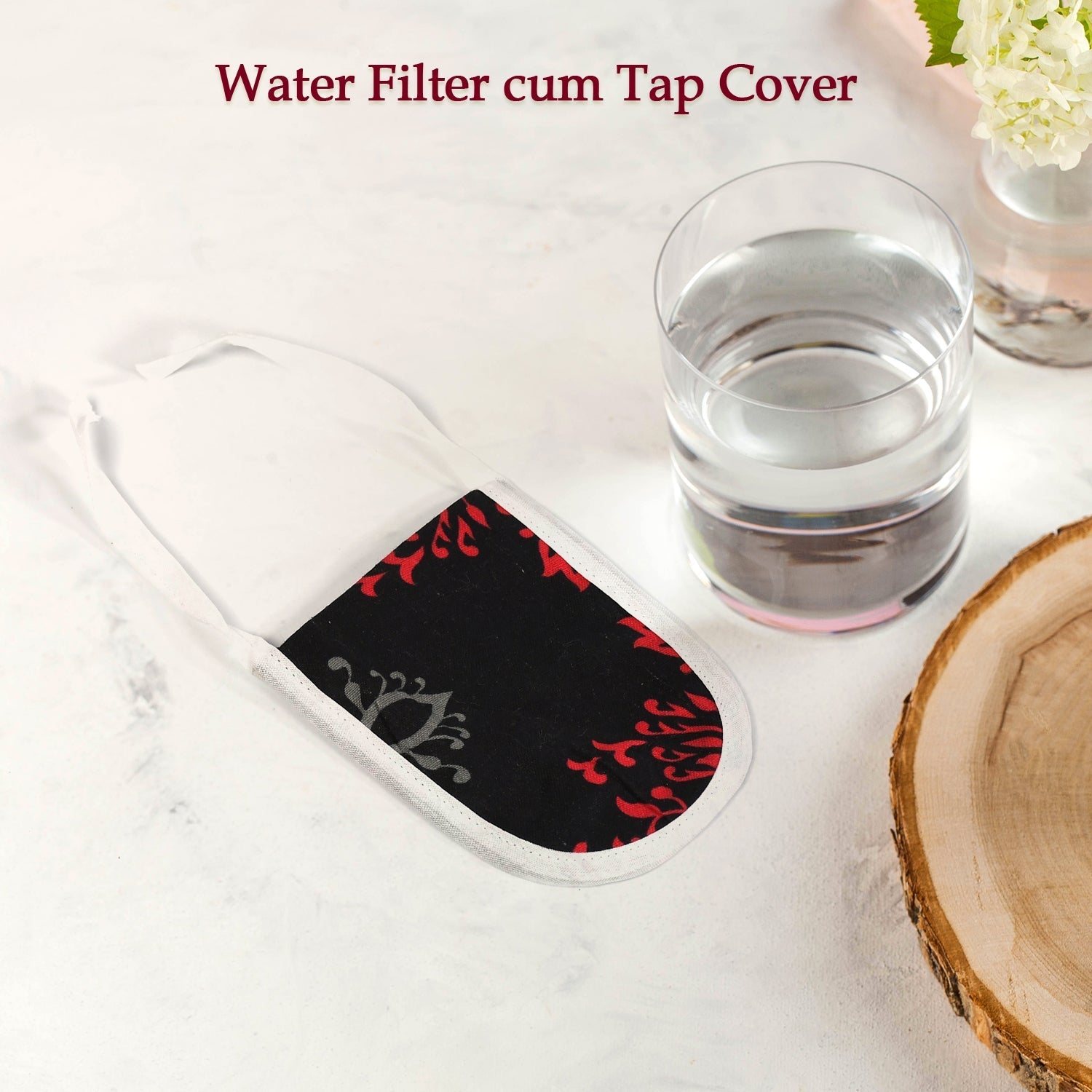 Decorative reusable cotton water filter cover placed next to a glass of water on a wooden surface