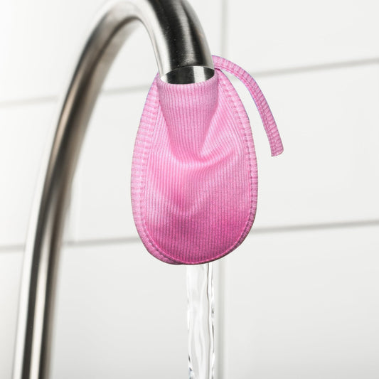 Reusable cotton water filter cover in pink hanging from a faucet for easy installation